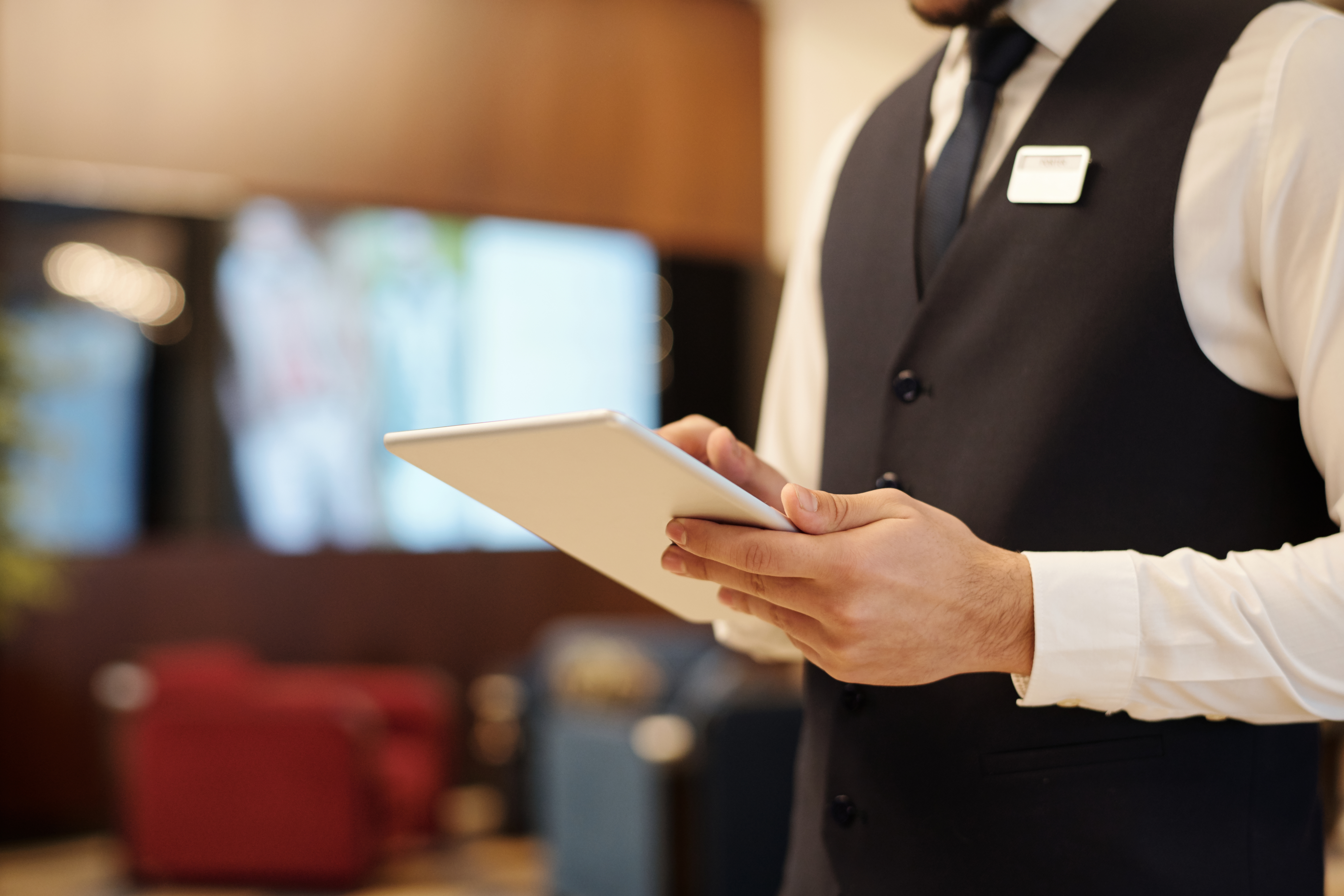Close Up,Of,Young,Elegant,Male,Receptionist,Using,Tablet,While,Standing